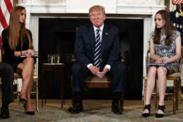 President Donald Trump, joined by Marjory Stoneman Douglas High School student Carson Abt, right, and Julia Cordover, the student body president at the school, pauses during a listening session with high school students teachers and others in the State Dining Room of the White House in Washington, Wednesday, Feb. 21, 2018. (AP Photo/Carolyn Kaster)