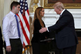 President Donald Trump greets Julia Cordover, the student body president at Marjory Stoneman Douglas High School in Parkland, Fla.,, as fellow student Jonathan Blank watches at a listening session with high school students and teachers in the State Dining Room of the White House in Washington, Wednesday, Feb. 21, 2018. (AP Photo/Carolyn Kaster)