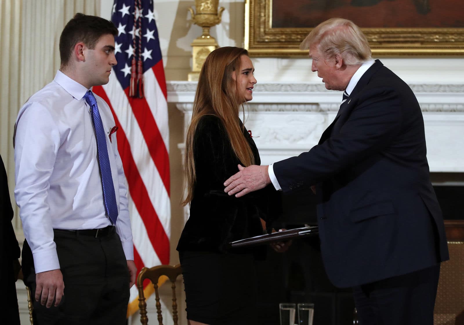 President Donald Trump greets Julia Cordover, the student body president at Marjory Stoneman Douglas High School in Parkland, Fla.,, as fellow student Jonathan Blank watches at a listening session with high school students and teachers in the State Dining Room of the White House in Washington, Wednesday, Feb. 21, 2018. (AP Photo/Carolyn Kaster)