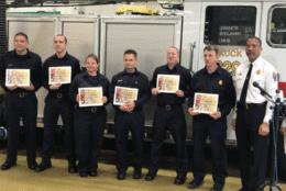 Members of the Prince George's County Fire Department being honored for saving 3 children from a home fire in Temple Hills
Pictured left to right.  Tyler Shoemaker, Zachary Stahly, Amanda Steele, Thomas Miller, Daniel Robinson, Michael Perritt and Chief Benjamin Barksdale. (WTOP/Kyle Cooper)

