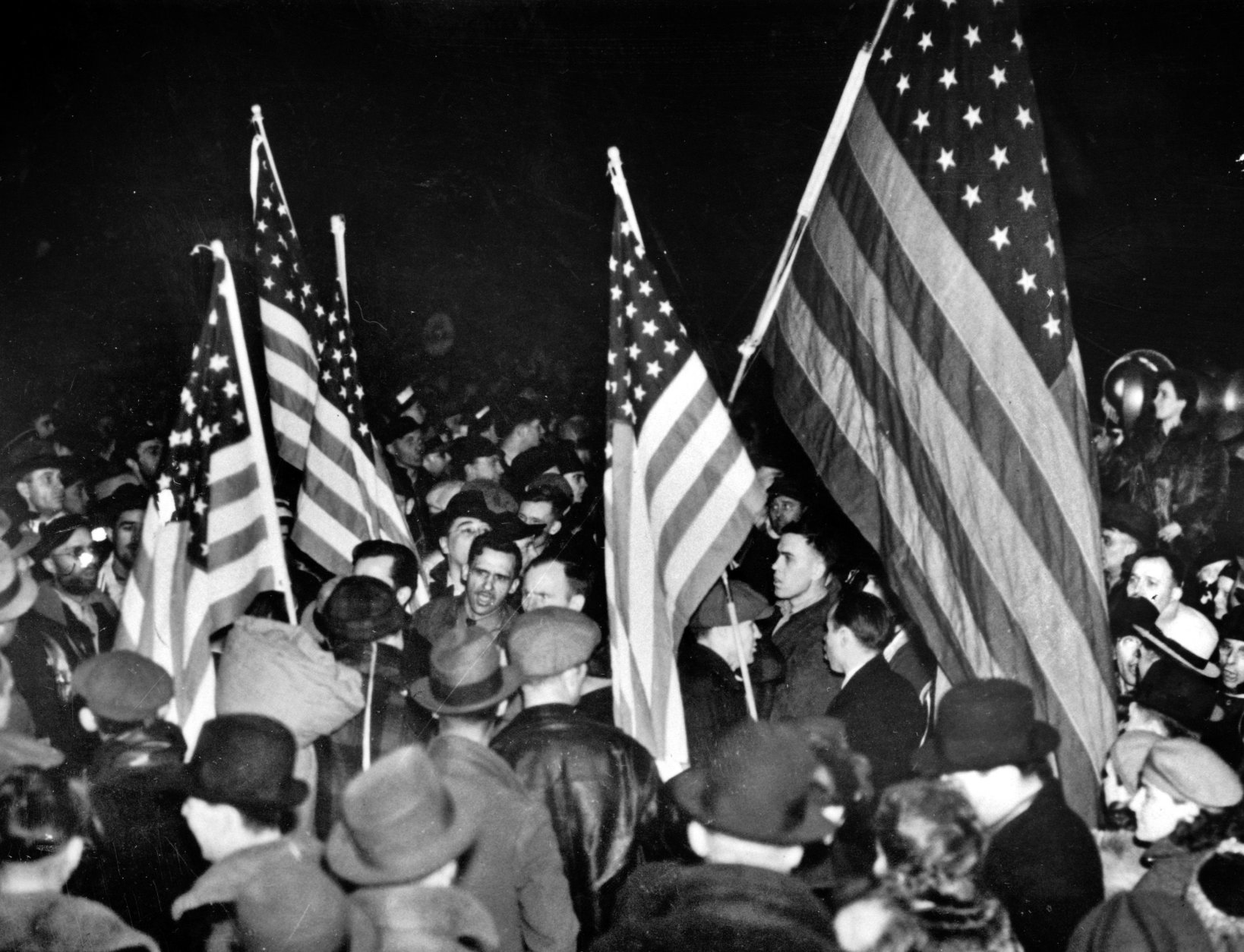 FILE - In this Feb. 12, 1937 file photo, strikers at the General Motors Fisher body plant in Flint, Mich., wave U.S. flags during the Great Depression. At its peak in the early 1970s, GM employed 80,000 people in Flint who cashed paychecks strengthened by the United Auto Workers union born in the city. Some 200,000 people lived in the city's limits, alongside sprawling factories, booming commerce, model schools and thriving arts. (AP Photo/File)