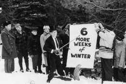 Sam Light, center, president of the Punxsutawney Groundhog Club, points to a sign held by members of the club in Gobbler's Knob, Punxsutawney, Pennsylvania, Jan. 1961.  They posed for the picture a few days before Groundhog Day, Feb. 2, with a stuffed stand-in for Punxsutawney Phil.  (AP Photo)