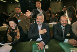 Ismail Haniyeh, Hamas' apparent choice for prime minister, center, replys to a greeting of lawmakers inside the Palestinian parliament in Gaza City, Saturday, Feb. 18, 2006. A Hamas-dominated Palestinian parliament was sworn in Saturday, and Palestinian leader Mahmoud Abbas was expected to ask the Islamic militant group in his opening address to accept his moderate policies, including negotiations with Israel. (AP Photo/Alexander Zemlianichenko)