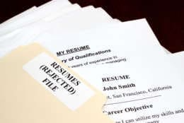 File with stack of rejected resumes