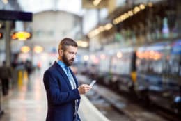 Young handsome businessman with smart phone in subway