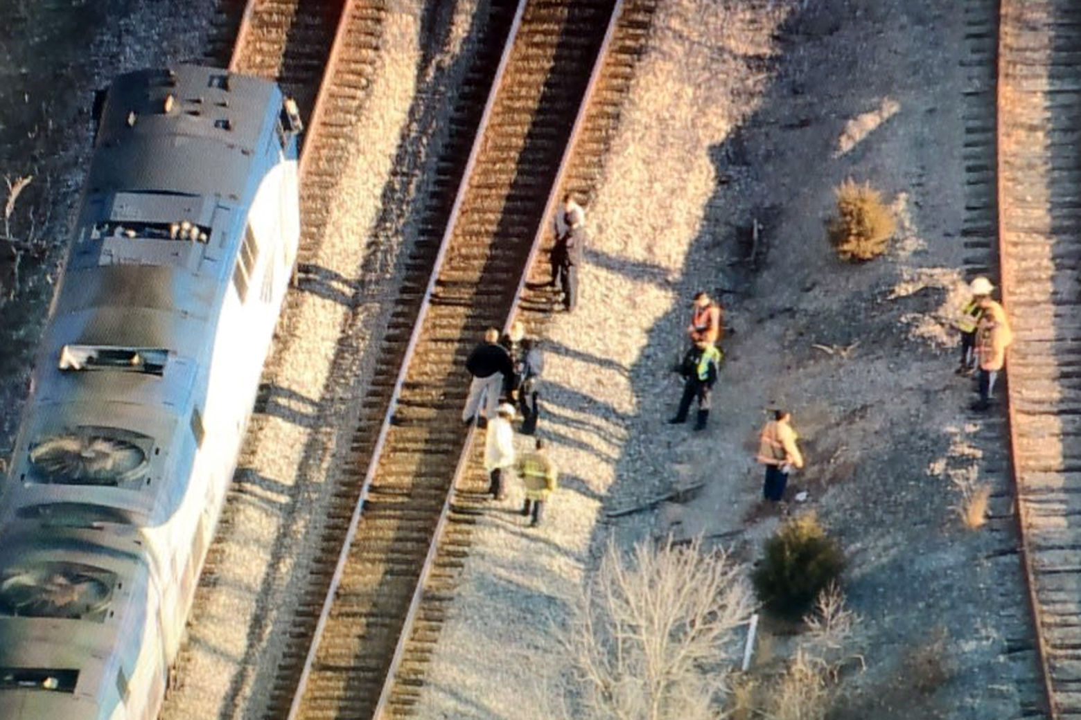 People on the tracks near where an Amtrak train struck a vehicle. (NBC Washington/Brad Freitas)