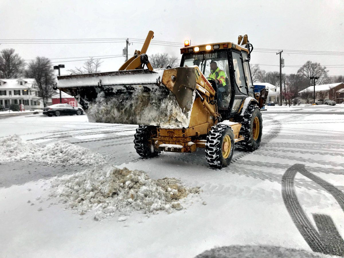 Contractors worked to clear snow from a grocery store parking lot in western Loudoun County, Virginia. (WTOP/Neal Augenstein)