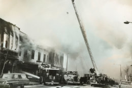 Perched high atop a ladder truck, a D.C. firefighter battles a blaze. (Courtesy D.C. Fire and EMS Museum)