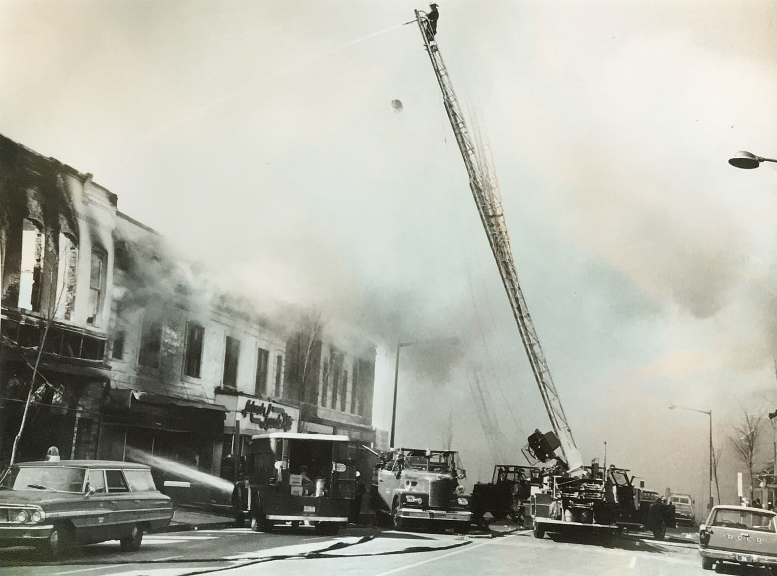 Perched high atop a ladder truck, a D.C. firefighter battles a blaze. (Courtesy D.C. Fire and EMS Museum)