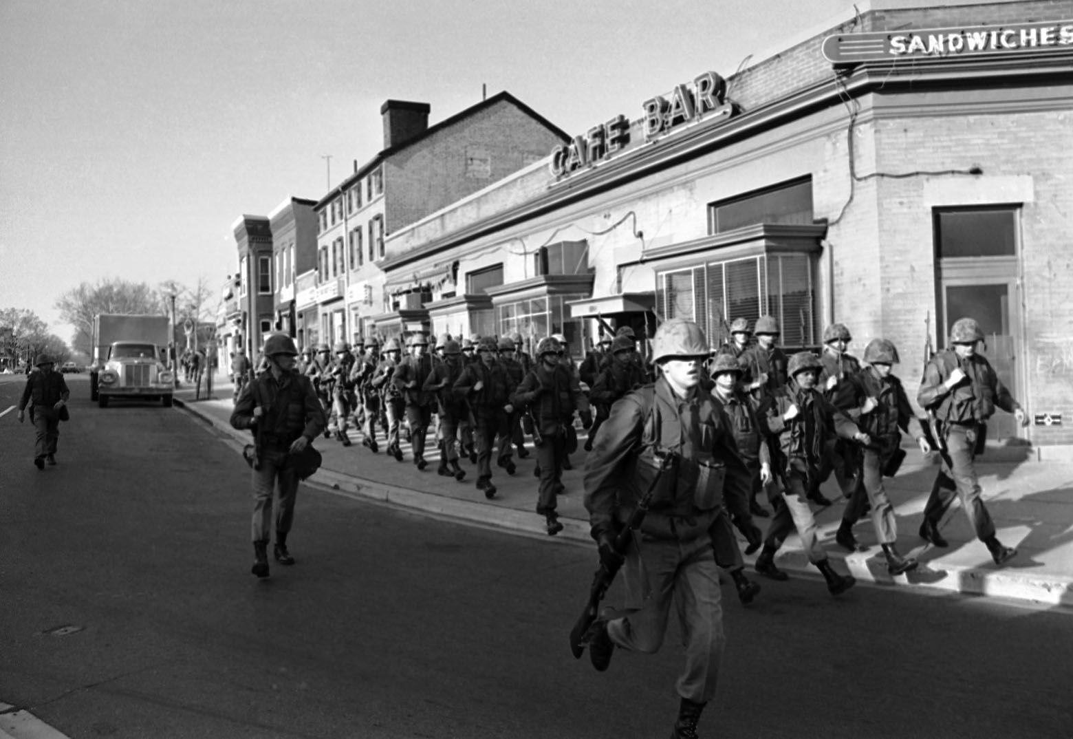 U.S. Marines move along 8th Street near M Street in southeast Washington on April 6, 1968. The Marines were among some 12,500 troops ordered into the city as new fires flared and looters roamed the streets. (AP Photo/Bob Schutz)
