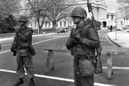 Two U.S. Marines stand guard at one of the entrances to the plaza at the U.S. Capitol Building in Washington on April 8, 1968. The city continued under rigid military control. (AP Photo/Charles Gorry)