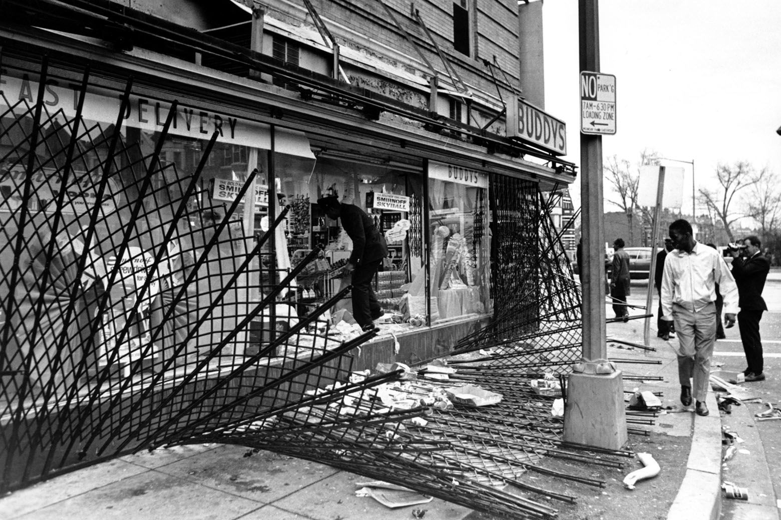 A policeman climbs over a protective screen and through the shattered glass front of a liquor store on 14th Street in Washington D.C. on April 5, 1968.  Violence broke out the day before in response to the assasination of the Rev. Martin Luther King Jr.  (AP Photo)