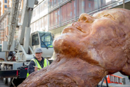 Crews install the 5-ton cast cement bust of Maya Angelou on 17th Street, between H and I Streets.  The piece, "Maya's Mind" is one of six outdoor art installations in the exhibit “No Spectators: Beyond the Renwick. (Photo credit Abram Eric Landes, Courtesy Golden Triangle BID)