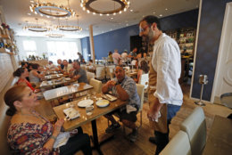 In this Tuesday, May 31, 2016 photo, Chef Alon Shaya, proprietor of Shaya Restaurant, talks to customers at his restaurant in New Orleans. In 2015, Shaya opened his namesake restaurant, a bustling Israeli eatery on chic Magazine Street that the James Beard Foundation in May named the Best New Restaurant in the U.S. (AP Photo/Gerald Herbert)