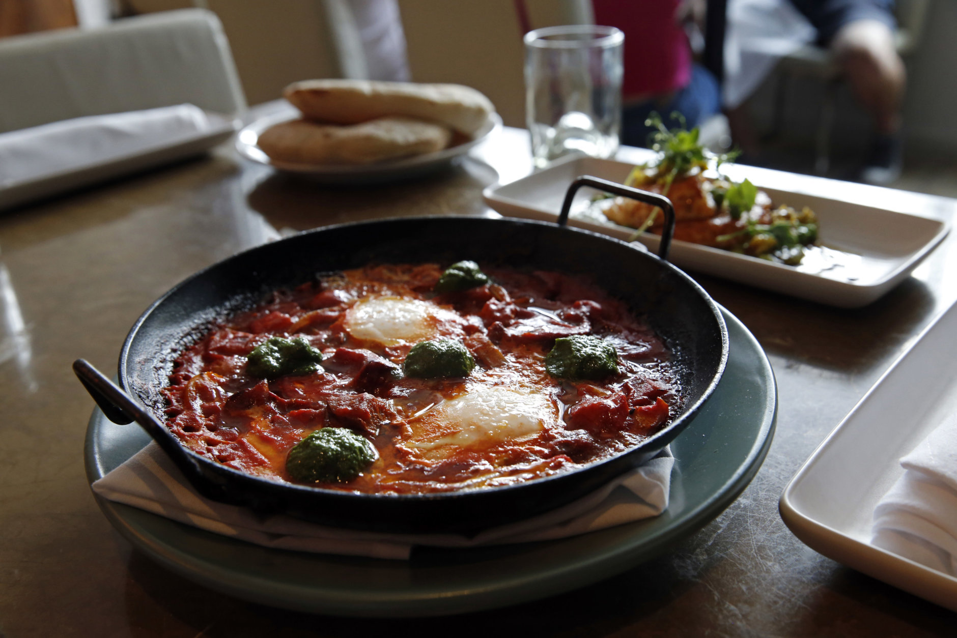 In this May 31, 2016 photo, Shakshouka, which is chermoula, Jerusalem artichokes, spicy chilies, tomato and egg, sits on a table at Shaya Restaurant, in New Orleans. In 2015, Shaya opened his namesake restaurant, a bustling Israeli eatery on chic Magazine Street that the James Beard Foundation in May named the Best New Restaurant in the U.S. (AP Photo/Gerald Herbert)