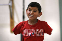 FILE - In this Dec. 10, 2016 file photo, Syrian refugee Ahmad Alkhalaf, whose arms were blown off above the elbows in a refugee camp bomb blast in 2014, smiles while playing with friends during a day camp in Sharon, Mass. In 2018, after seven years of war in Syria, the United Nations has one thing to say: Stop the war on children. Of Syria’s estimated 10 million children, 8.6 million are now in dire need of assistance and nearly 6 million children are displaced or living as refugees. (AP Photo/Charles Krupa, File)