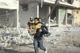 This file photo released Feb. 21, 2018 provided by the Syrian Civil Defense group known as the White Helmets, shows a member of the White Helmets carrying a boy who was wounded during airstrikes and shelling by Syrian government forces, in Ghouta, a suburb of Damascus, Syria. In 2018, after seven years of war in Syria, the United Nations has one thing to say: Stop the war on children. Of Syria’s estimated 10 million children, 8.6 million are now in dire need of assistance. While the U.N. has verified about 2,500 children killed between 2014 and 2017, it says the actual numbers are much higher. (Syrian Civil Defense White Helmets via AP, File)