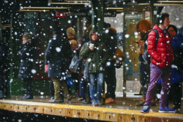 Commuters are sheltered from snowfall while waiting on a subway platform, Tuesday March 13, 2018, in the Brooklyn borough of New York. The National Weather Service predicted between two and five inches of snow in the city and surrounding areas, where a winter weather advisory was in effect. (AP Photo/Bebeto Matthews)