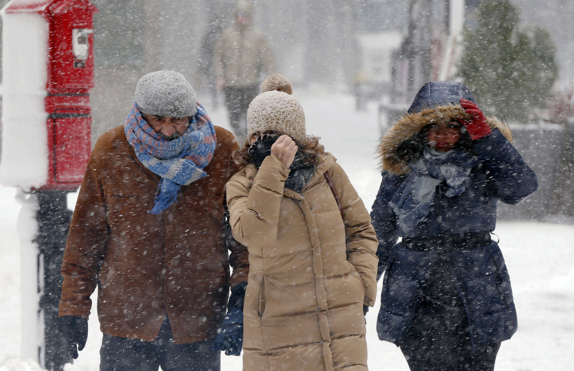 Pedestrians make their way through blowing snow during a snowstorm, Tuesday, March 13, 2018, in Boston. (AP Photo/Michael Dwyer)