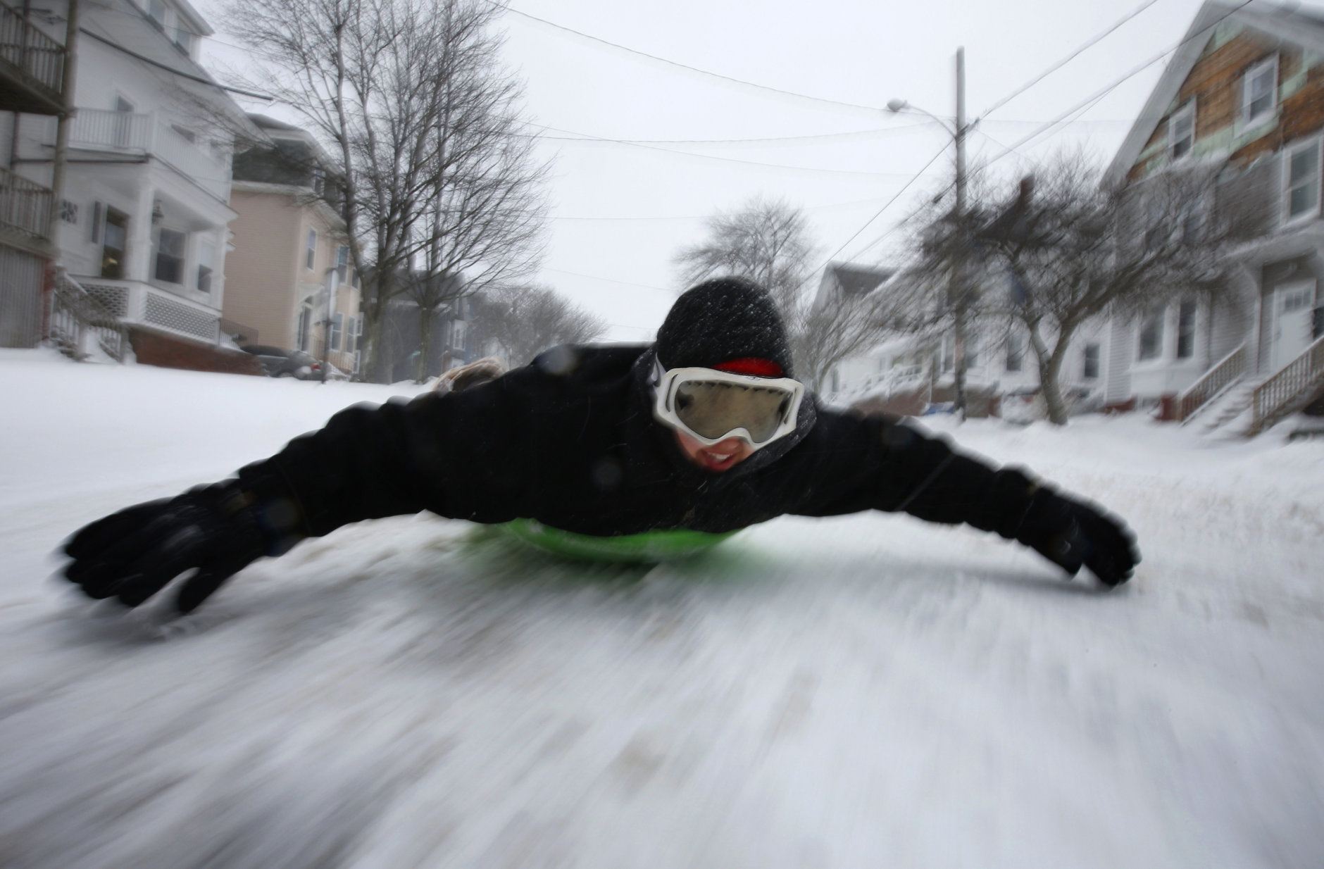 Gabby DiGiacomo, of Whitefield, Maine, slides down Congress Street in Portland, Maine, on a saucer during the latest winter storm, Tuesday, March 13, 2018, in Portland, Maine. With the exception of snowplows, the streets had very little traffic during the third major nor'easter in two weeks to slam the storm-battered Northeast. (AP Photo/Robert F. Bukaty)