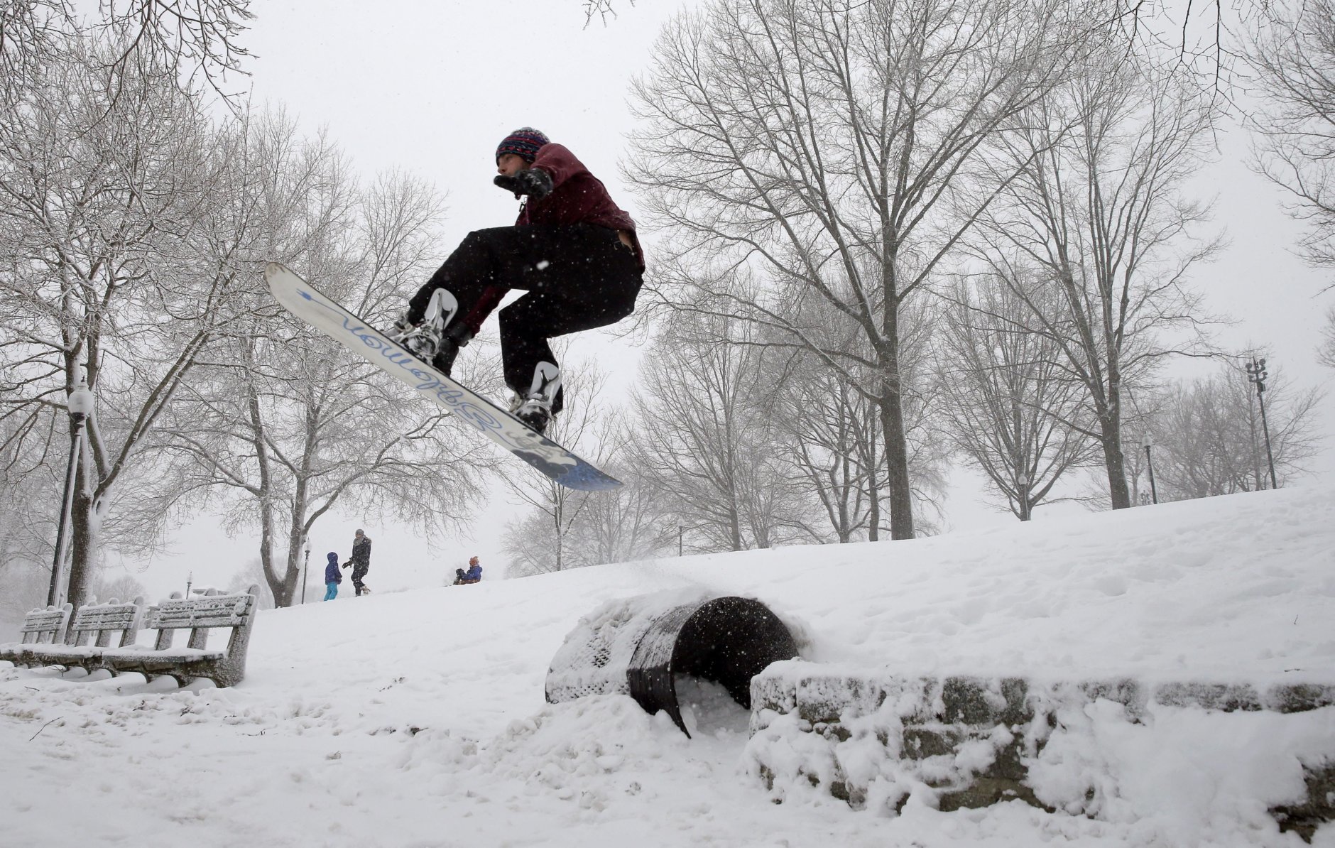 A snowboarder soars during a snowstorm, Tuesday, March 13, 2018, in Boston. The third major nor’easter in two weeks slammed New England on Tuesday, bringing blizzard conditions and more than a foot of snow to some communities.   (AP Photo/Michael Dwyer)