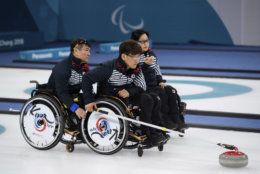 Soonseok Seo, center, of South Korea throws a stone during the Wheelchair Curling Bronze Medal Game between South Korea and Canada at the Gangneung Curling Centre  in Gangneung, South Korea at the 2018 Winter Paralympics Saturday, March 17, 2018. (Joel Marklund/OIS/IOC via AP)