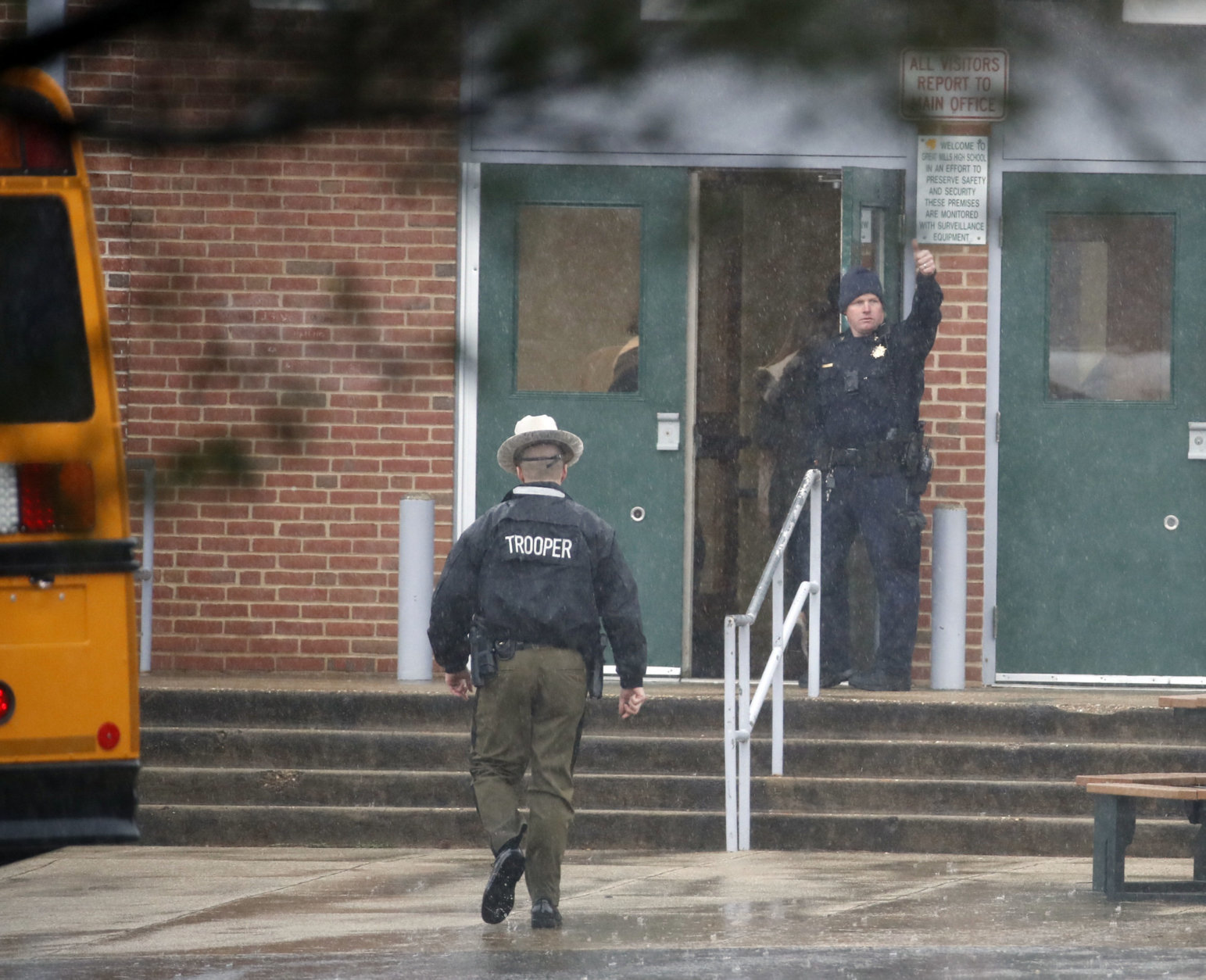 A policeman gives a thumbs-up after moving students into a different area of Great Mills High School, the scene of a shooting, Tuesday morning, March 20, 2018 in Great Mills, Md.  (AP Photo/Alex Brandon  )