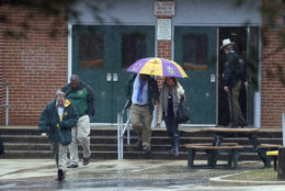 Teachers and school employees depart Great Mills High School, the scene of a shooting, Tuesday, March 20, 2018 in Great Mills, Md.  A teenager wounded a girl and a boy inside his Maryland high school Tuesday before an armed school resource officer was able to intervene, and each of them fired one more round as the shooter was fatally wounded, a sheriff said.  St. Mary's County Sheriff Tim Cameron said the student with the handgun was declared dead at a hospital, and the other two students were in critical condition. He said the officer was not harmed.  (AP Photo/Alex Brandon)
