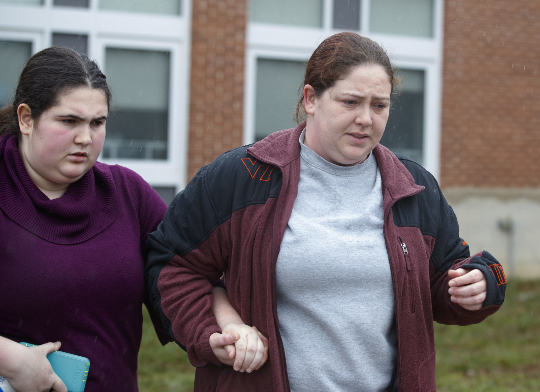 A mother walks her daughter, a student from Great Mills High School, to the car as she picks her up from Leonardtown High School in Leonardtown, Md., Tuesday, March 20, 2018.  A teenager wounded a girl and a boy inside his Maryland high school Tuesday before a school resource officer was able to intervene, and each of them fired one more round as the shooter was fatally wounded, a sheriff said. St. Mary's County Sheriff Tim Cameron said the student with the handgun was declared dead at a hospital, and the other two students were in critical condition.  (AP Photo/Carolyn Kaster)