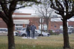 Parents walk with their children, students from Great Mills High School, as they pick them up from Leonardtown High School in Leonardtown, Md., Tuesday, March 20, 2018.   A teenager wounded a girl and a boy inside his Maryland high school Tuesday before a school resource officer was able to intervene, and each of them fired one more round as the shooter was fatally wounded, a sheriff said. St. Mary's County Sheriff Tim Cameron said the student with the handgun was declared dead at a hospital, and the other two students were in critical condition. (AP Photo/Carolyn Kaster)