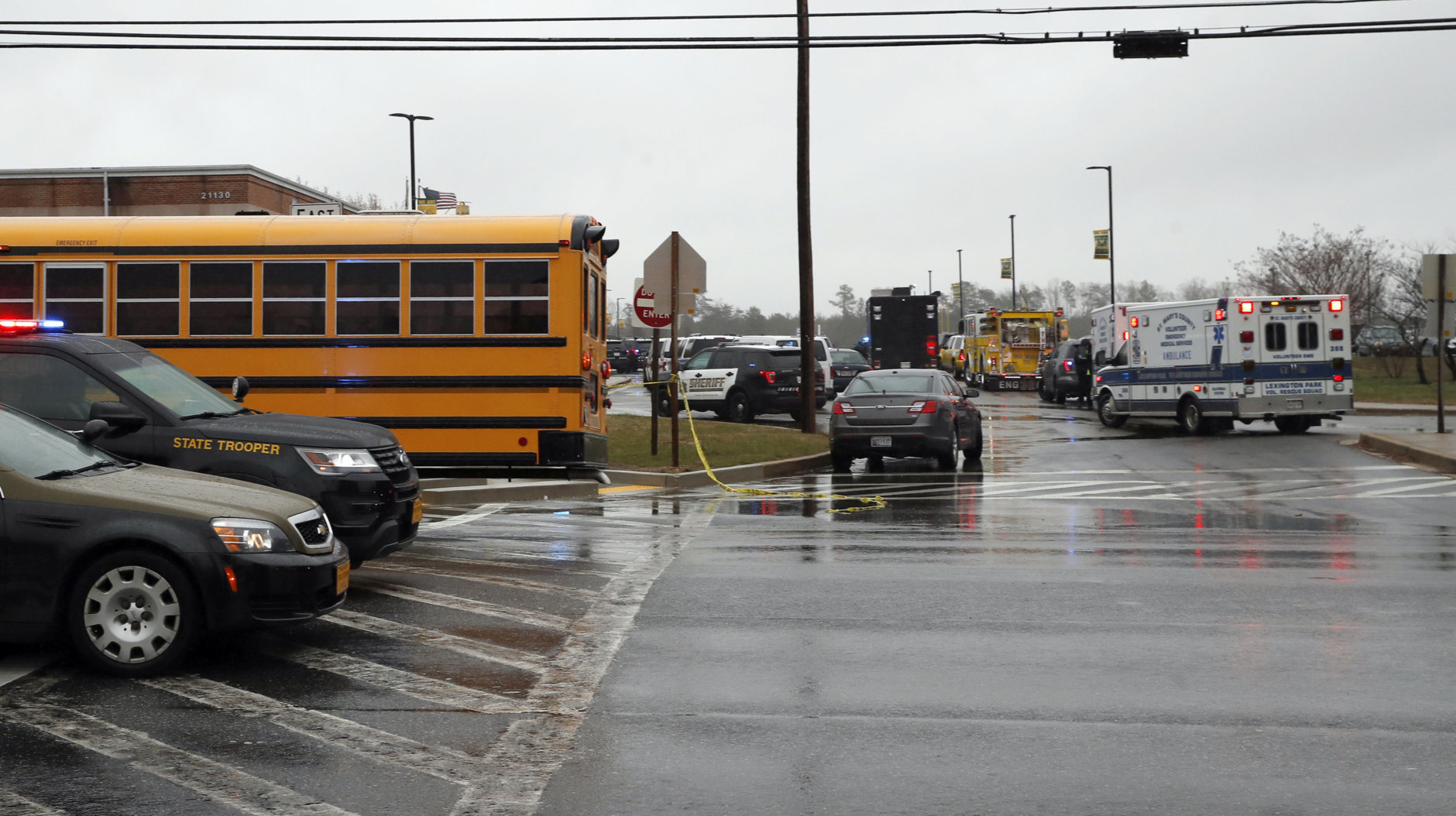 Vehicles of first responders and school buses are parked at the entrance to Great Mills High School Tuesday, March 20, 2018, in Great Mills. A student with a handgun shot two classmates inside the high school before he was fatally wounded during a confrontation with a school resource officer, a sheriff said. (AP Photo/Alex Brandon)