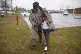 A father shelters his daughter, a student from Great Mills High School, from the rain as they picks her up from Leonardtown High School in Leonardtown, Md., Tuesday, March 20, 2018.  A student with a handgun shot two classmates inside his Maryland high school before he was fatally wounded during a confrontation with a school resource officer, a sheriff said. (AP Photo/Carolyn Kaster)