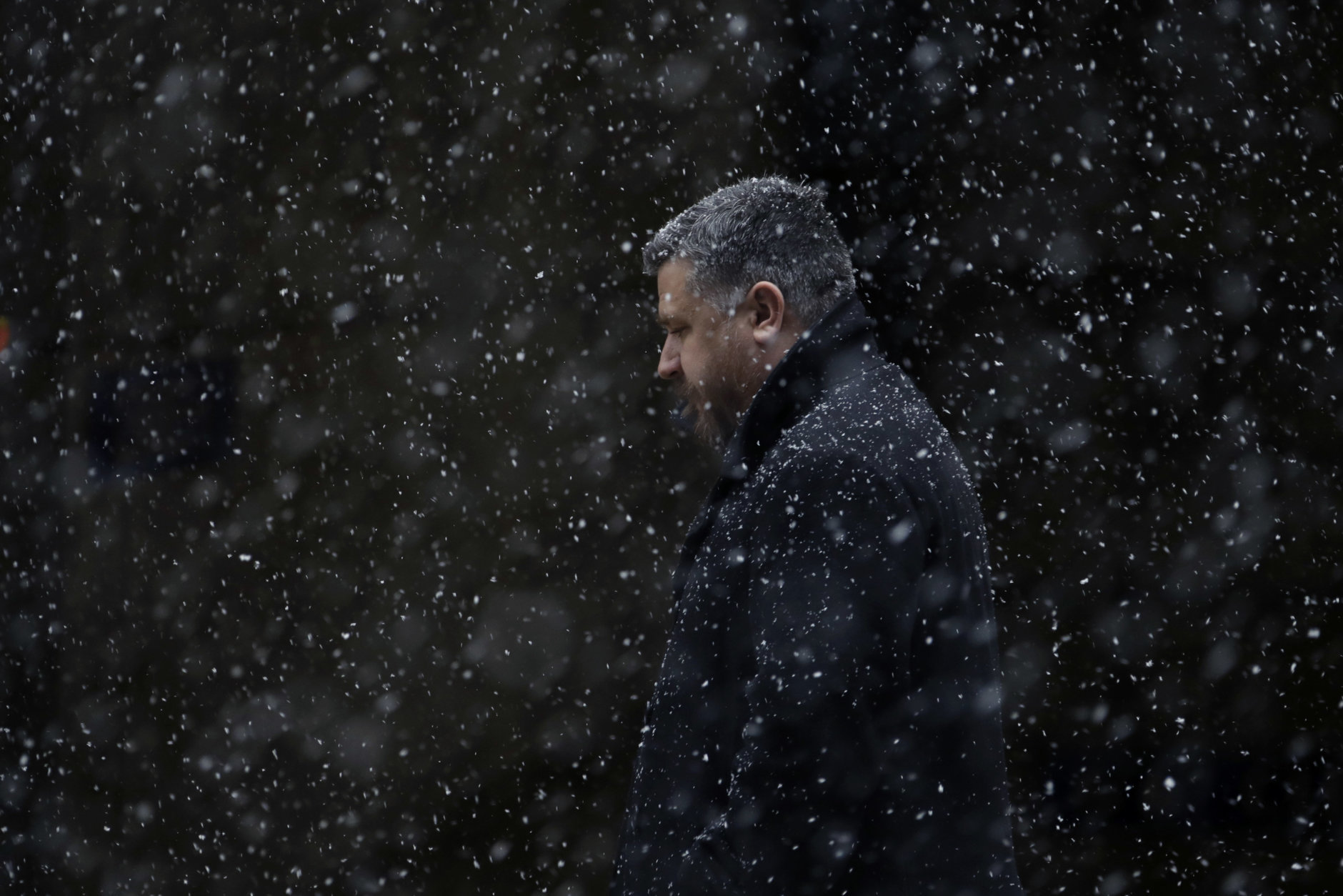A man walks through falling snow during a winter storm, Tuesday, March 20, 2018, in Philadelphia. (AP Photo/Matt Slocum)