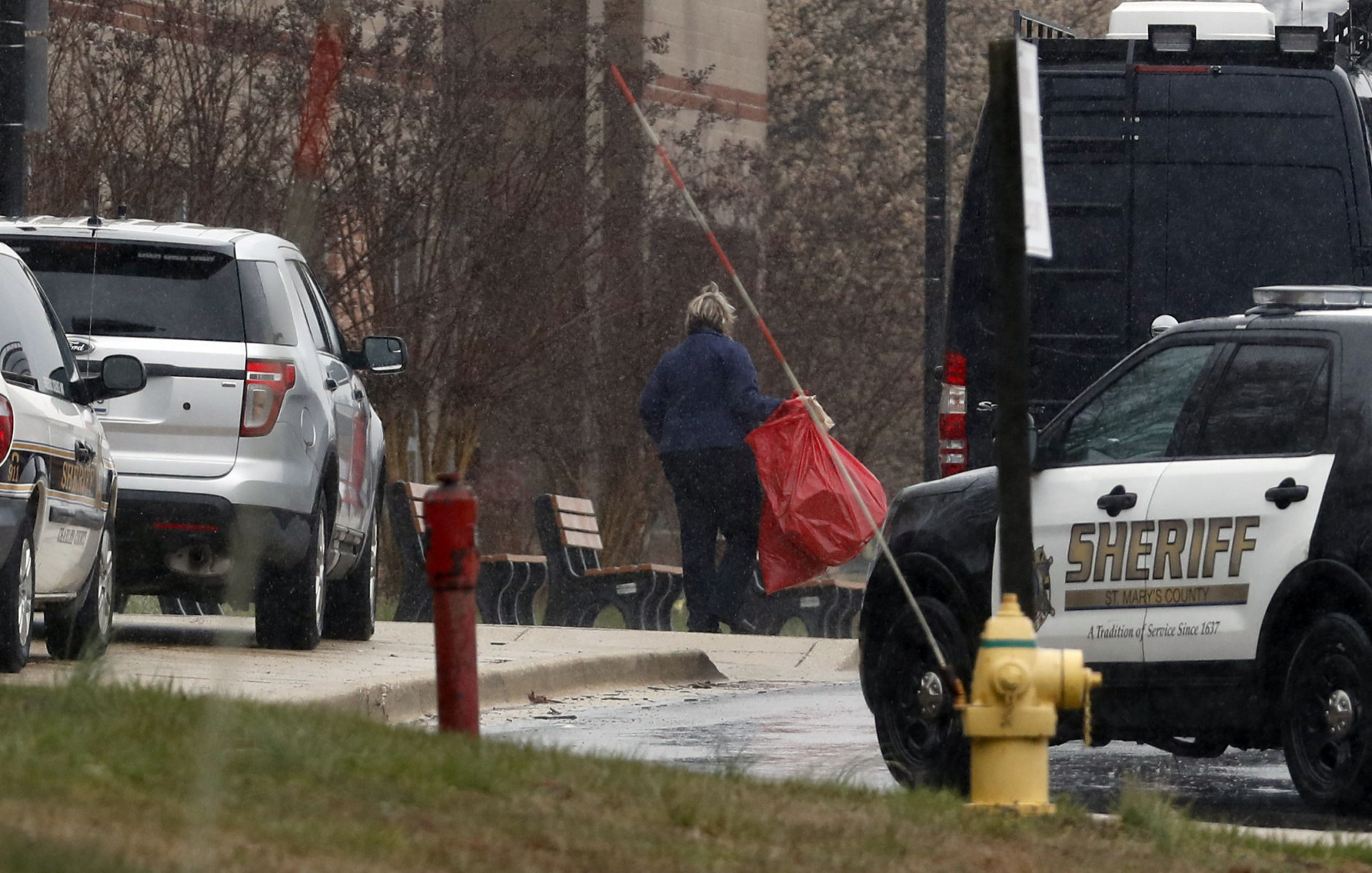 A bag is removed and taken to the crime scene van at Great Mills High School, the scene of a shooting, Tuesday, March 20, 2018, in Great Mills. A student with a handgun shot two classmates inside the school before he was fatally wounded during a confrontation with a school resource officer, a sheriff said.  (AP Photo/Alex Brandon)