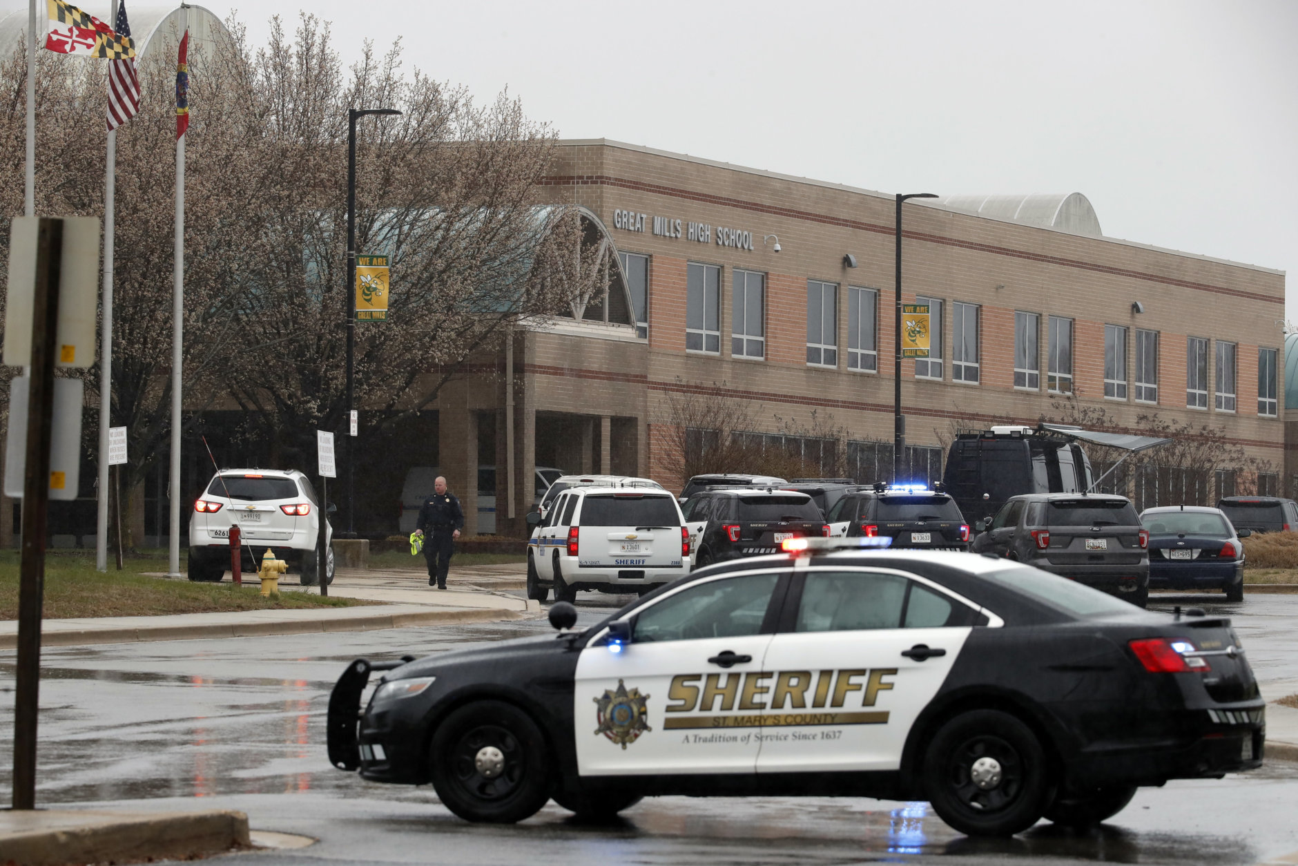 A law enforcement officer walks in front of Great Mills High School, the scene of a shooting, Tuesday, March 20, 2018, in Great Mills. A student with a handgun shot two classmates inside the school before he was fatally wounded during a confrontation with a school resource officer, a sheriff said.  (AP Photo/Alex Brandon)