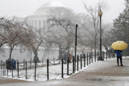 People brave the snow as it begins to fall in earnest near the Jefferson Memorial, Wednesday, March 21, 2018, at the tidal basin in Washington during a snow storm on the second day of spring. (AP Photo/Jacquelyn Martin)