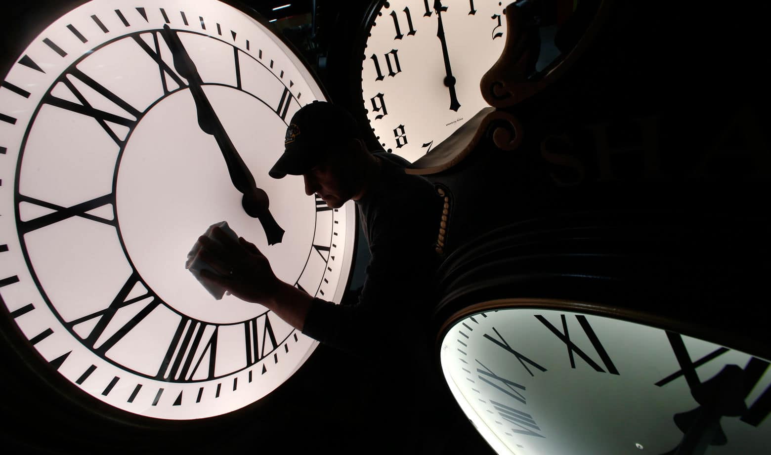 Dave LeMote wipes down a post clock at Electric Time Company, Inc. in Medfield, Mass., Friday, March 7, 2014. Most Americans will set their clocks 60 minutes forward before heading to bed Saturday night, but daylight saving time officially starts Sunday at 2 a.m. local time (0700GMT). (AP Photo/Elise Amendola)