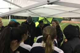 Players huddle under a tent during a rainy practice. (Courtesy: DCIAA/Shanice Abrams)