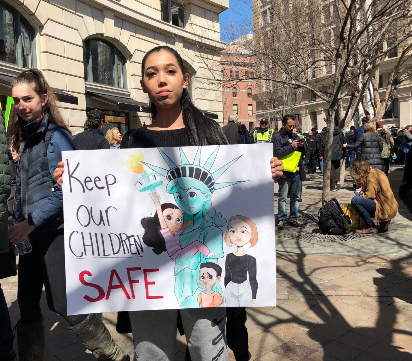Serena Corbin from Woodbridge, Virginia, holds up a sign that reads, "Keep our children safe." (WTOP/Kate Ryan)