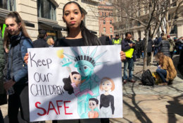 Serena Corbin from Woodbridge, Virginia, holds up a sign that reads, "Keep our children safe." (WTOP/Kate Ryan)