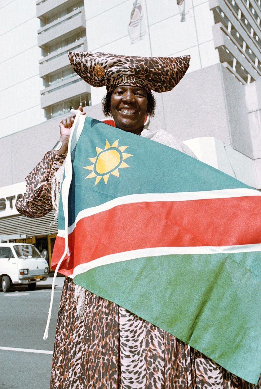 A Hararo woman holds the new Namibian flag which is to be hoisted in a ceremony when Nambia becomes independent after being under South African rule for 75 years, in Windhoek, Namibia, March 19, 1990. (AP Photo/John Parkin)