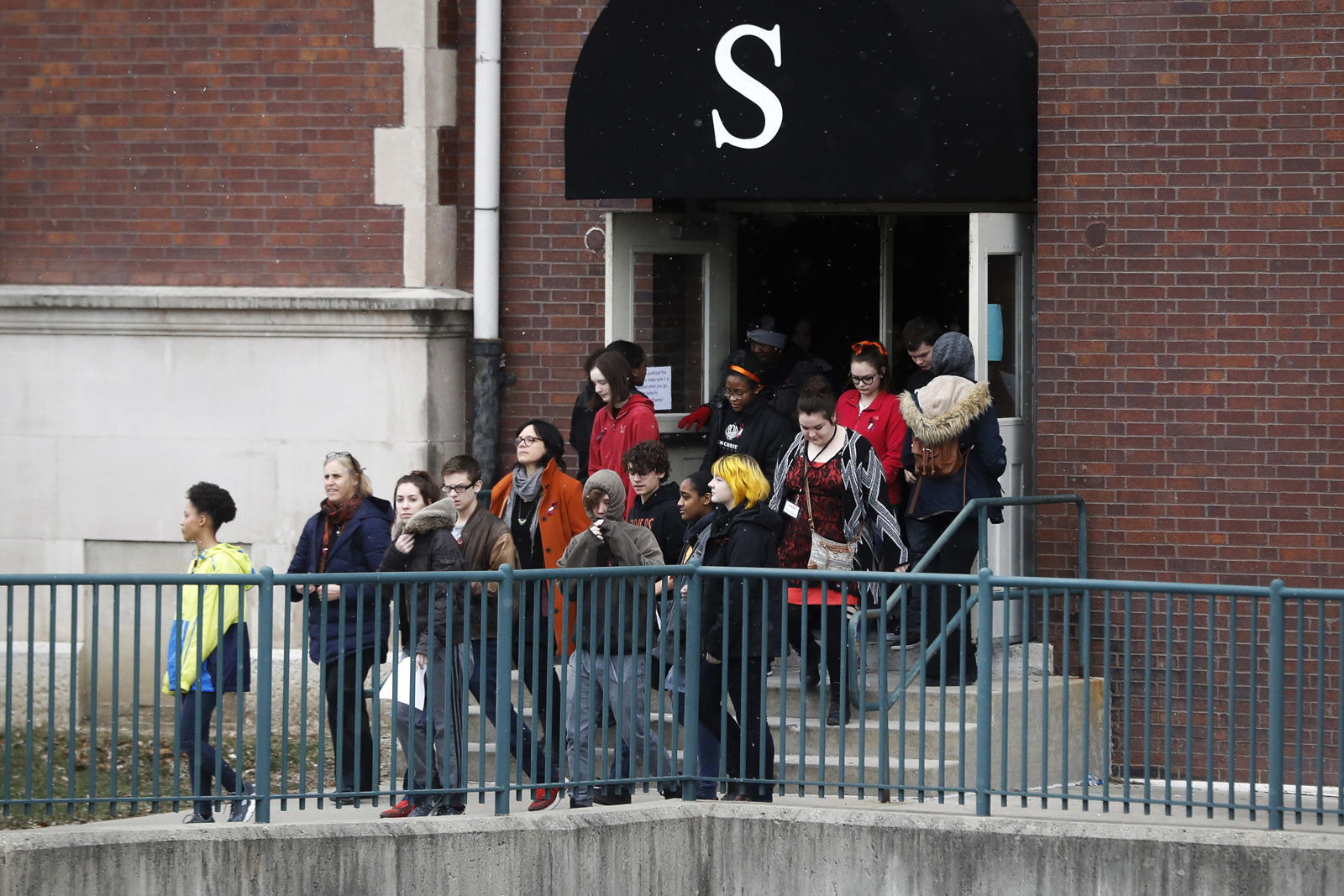 Students exit the building before gathering on their soccer field during a 17-minute walkout protest at the Stivers School for the Arts, Wednesday, March 14, 2018, in Dayton, Ohio. Students across the country planned to participate in walkouts Wednesday to protest gun violence, one month after the deadly shooting inside a high school in Parkland, Fla. (AP Photo/John Minchillo)