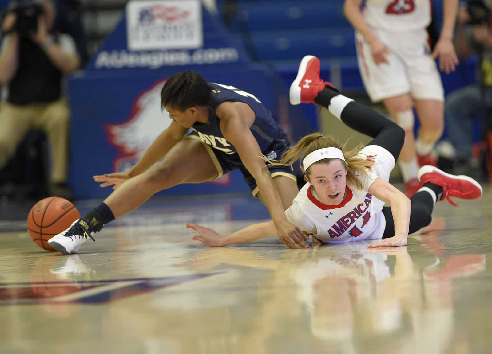 American guard Maria Liddane (14) battles for the ball against Navy guard Bianca Roach (15) during the first half an NCAA college basketball game for the Patriot League women's tournament championship, Sunday, March 11, 2018, in Washington. (AP Photo/Nick Wass)