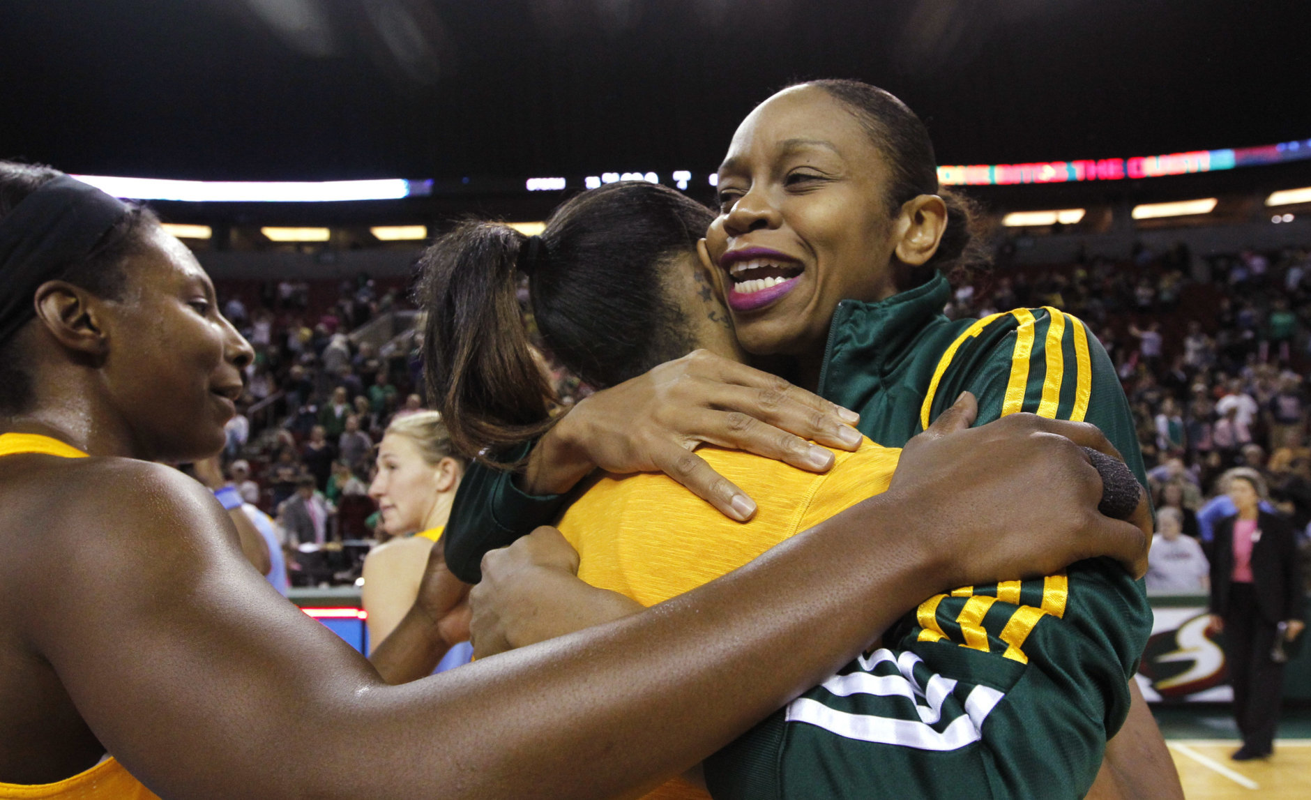 Seattle Storm's Tina Thompson, right, is embraced by Chicago Sky players following a WNBA basketball game, Tuesday, Sept. 18, 2012, in Seattle. The Storm won 75-60. Thompson, the all-time scoring leader in the WNBA, became the first and only player to reach 7,000 career points. She reached the milestone during the first half of their game. (AP Photo/Elaine Thompson)