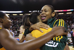 Seattle Storm's Tina Thompson, right, is embraced by Chicago Sky players following a WNBA basketball game, Tuesday, Sept. 18, 2012, in Seattle. The Storm won 75-60. Thompson, the all-time scoring leader in the WNBA, became the first and only player to reach 7,000 career points. She reached the milestone during the first half of their game. (AP Photo/Elaine Thompson)