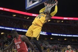 Wichita State center Shaquille Morris (24) hangs on the rim after dunking over Houston forward Nura Zanna (13) during the second half of an NCAA college basketball semifinal game at the American Athletic Conference tournament Saturday, March 10, 2018, in Orlando, Fla. Houston won 77-74. (AP Photo/Phelan M. Ebenhack)