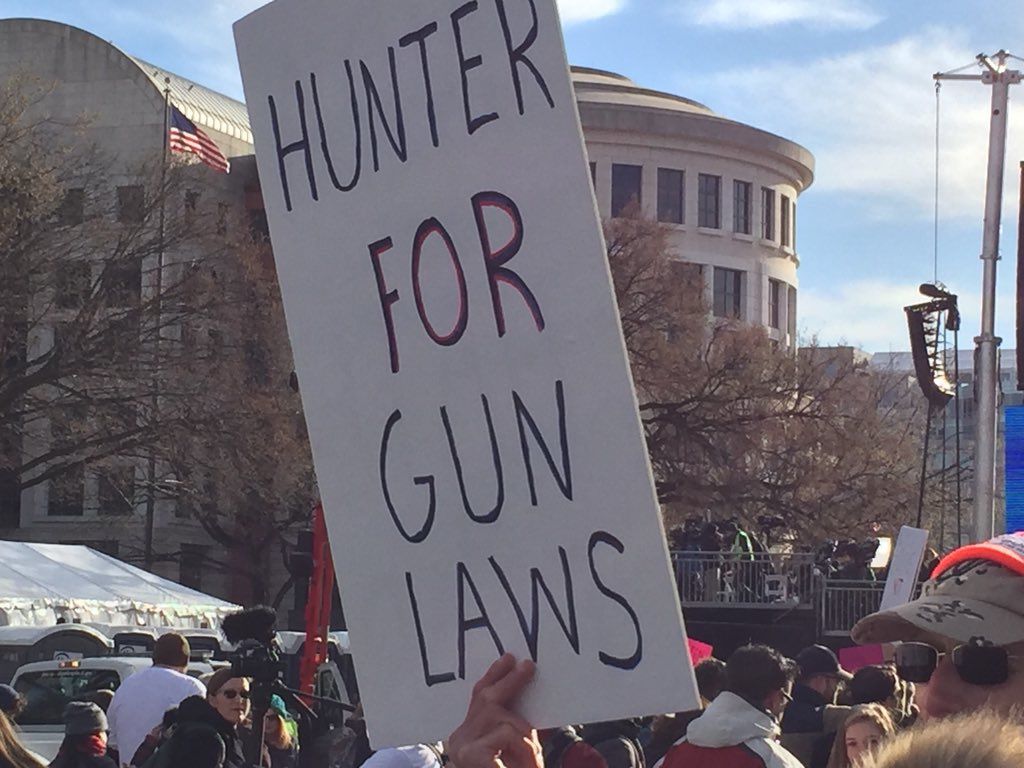 In this photo, Eric Ripper, of Fort Belvoir, Virginia, holds a sign that says, "Hunter for gun laws." (WTOP/John Domen)