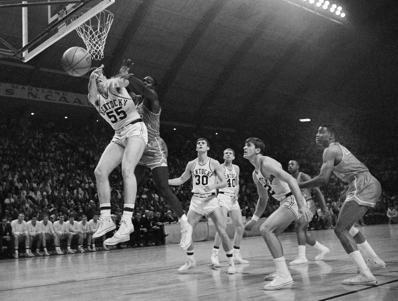 FILE - In this March 19, 1966, file photo, Kentucky's Thad Jaracz (55) and Texas Western's David Latin (42) reach for a rebound during the first period of the NCAA men's baksetball championship game in College Park, Md. Other Kentucky players shown are Tommy Kron (30) and Larry Conley (40). Fifty years ago, Texas Western started five blacksWillie Worsley, Orsten Artis, Bobby Joe Hill, David "Big Daddy" Lattin and Harry Flournoyagainst Kentucky in the game. Today, after reading historical recaps and watching movies, people tend to think it was an immediate watershed moment in sports and civil rights. It wasn't. (AP Photo/File)