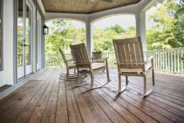 Rocking chairs grace a upper porch in a large lake front home in the Southern USA.