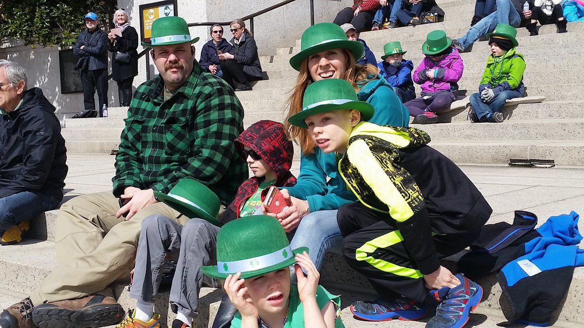 In this a photo, a family enjoys the parade, decked out in green. (WTOP/Kathy Stewart)